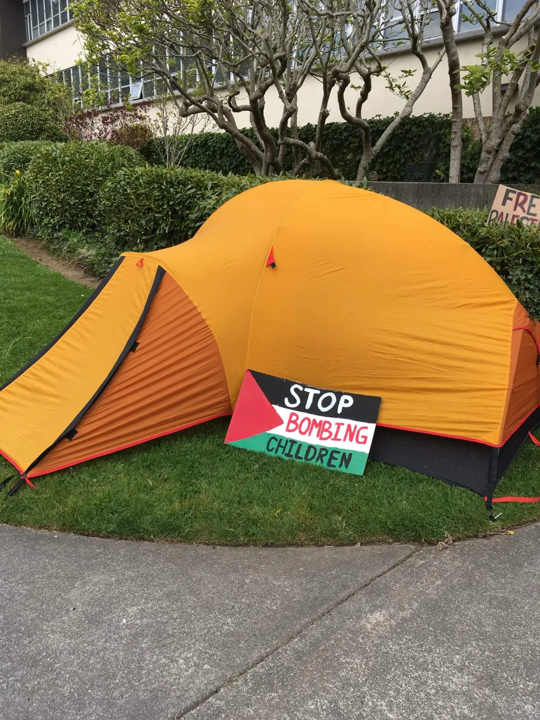 An orange tent with a hand painted sign 